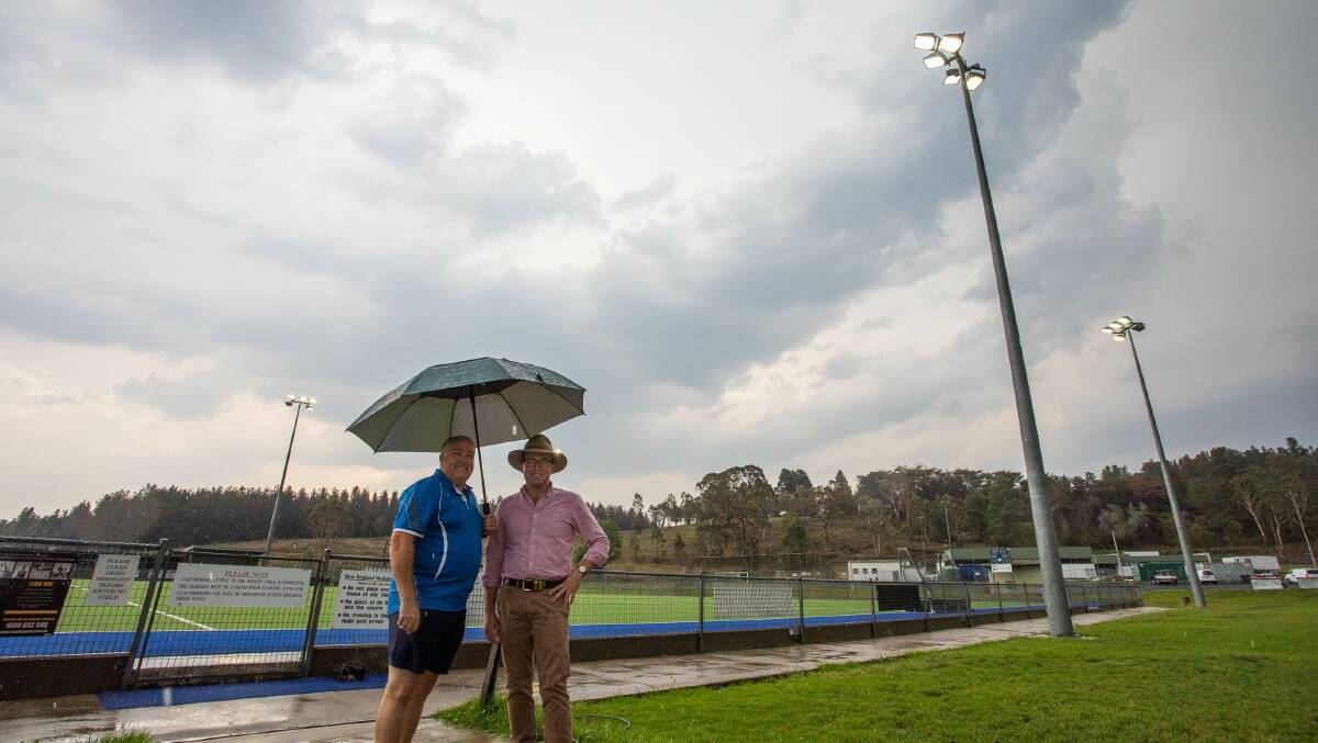 Hockey New England Vice President Mark Low and Northern Tablelands MP Adam Marshall in front of the hockey turf which will soon have new LED lights installed.