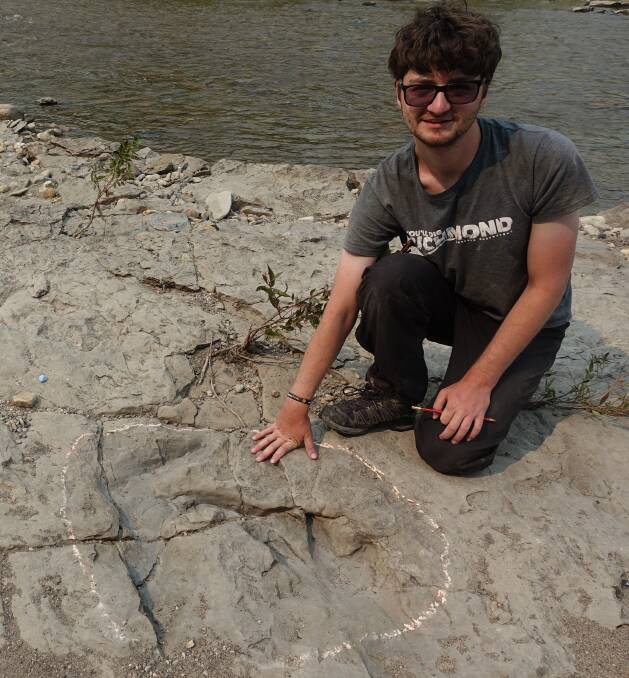 DINOSAUR DISCOVERY: Nathan Enriquez next to dinosaur footprints in the Canadian region of northern Alberta. Picture: Supplied