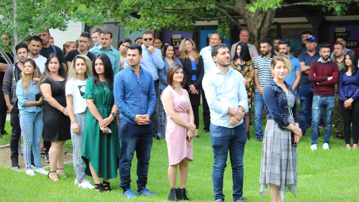 Armidale's Ezidi refugees line up to receive certificates in recognition of their English language studies at Armidale TAFE last year.