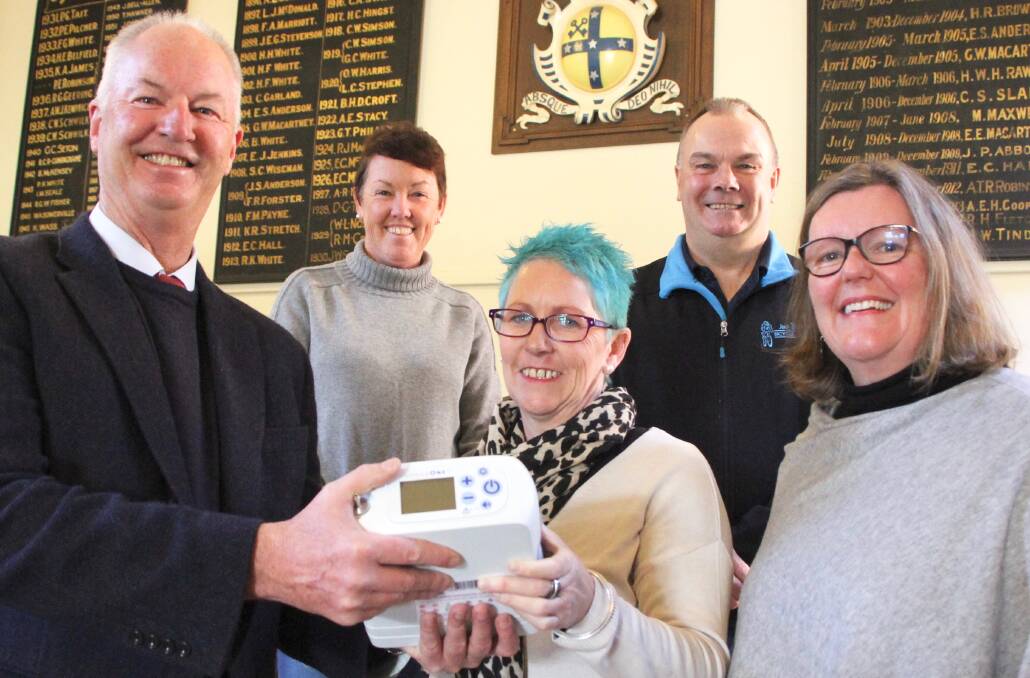 Alan Jones presents the oxygen concentrator to Kim Taylor, watched by Kay Endres (Tour de Rocks) and Mark Bullen (Armidale Bicycle Centre) who supported the event and Hunter New England Health mental health care professional Fiona Simmons.
