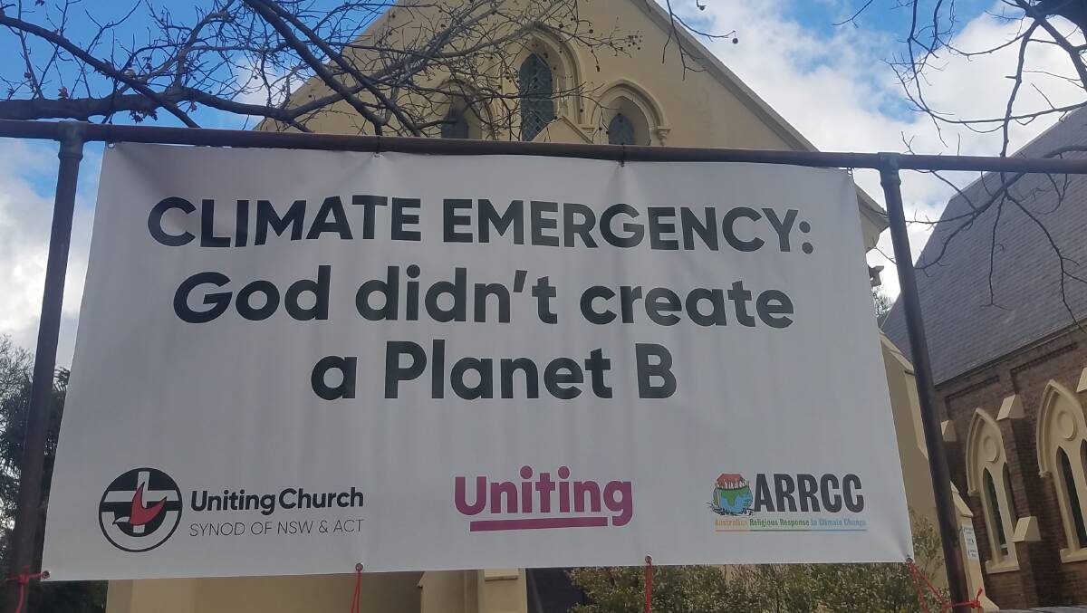 A banner hangs outside the Armidale Uniting Church with a message about climate change.