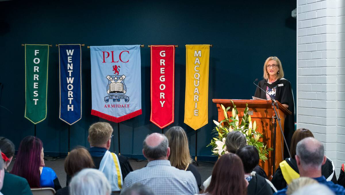 PLC principal Nicola Taylor alongside the school's guild banners.