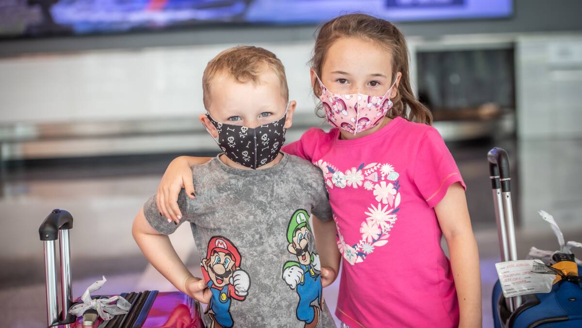 Austin, 5, and Evie Matthews, 7, wearing masks at Canberra Airport on Friday after returning home. Masks are now mandatory on all flights. Picture: Karleen Minney