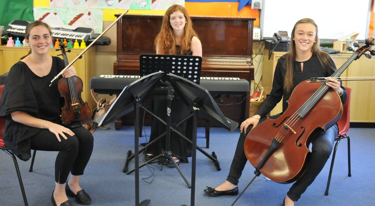 Travelling trio: Musicians from the New England Conservatorium, Eliza Scott, Meg Burstow and Charlotte Low set up to perform for students.