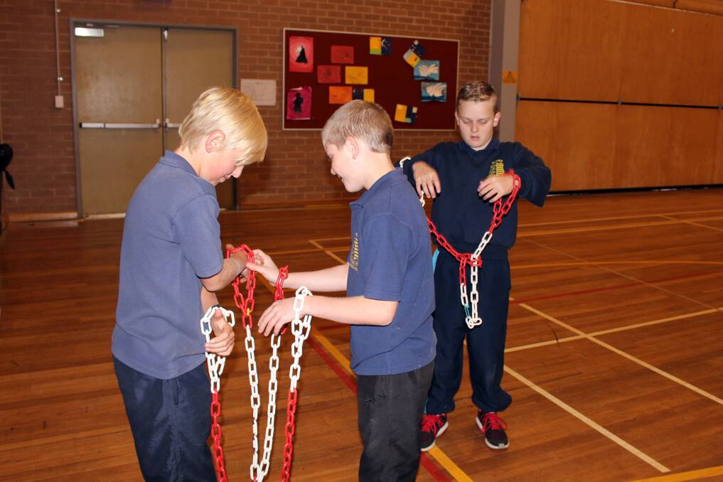 Brodi Campbell, Kye Yeomans and Riley Campbell in chains.