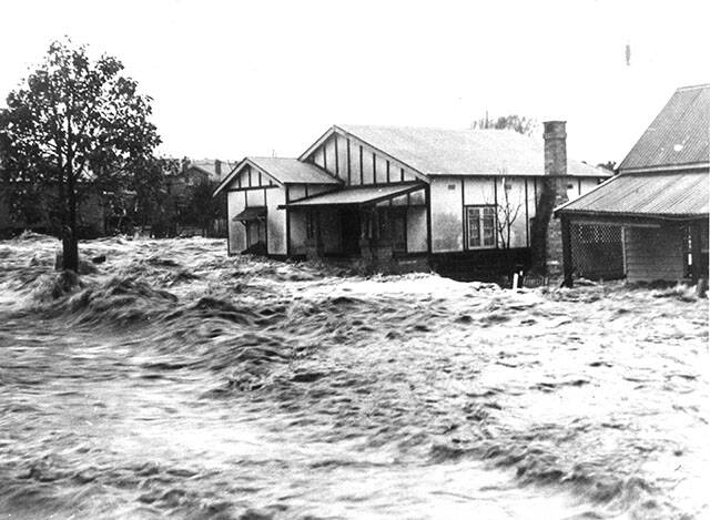 Raging waters: The dramatic Kempsey flood of 1949 rushes past a house.