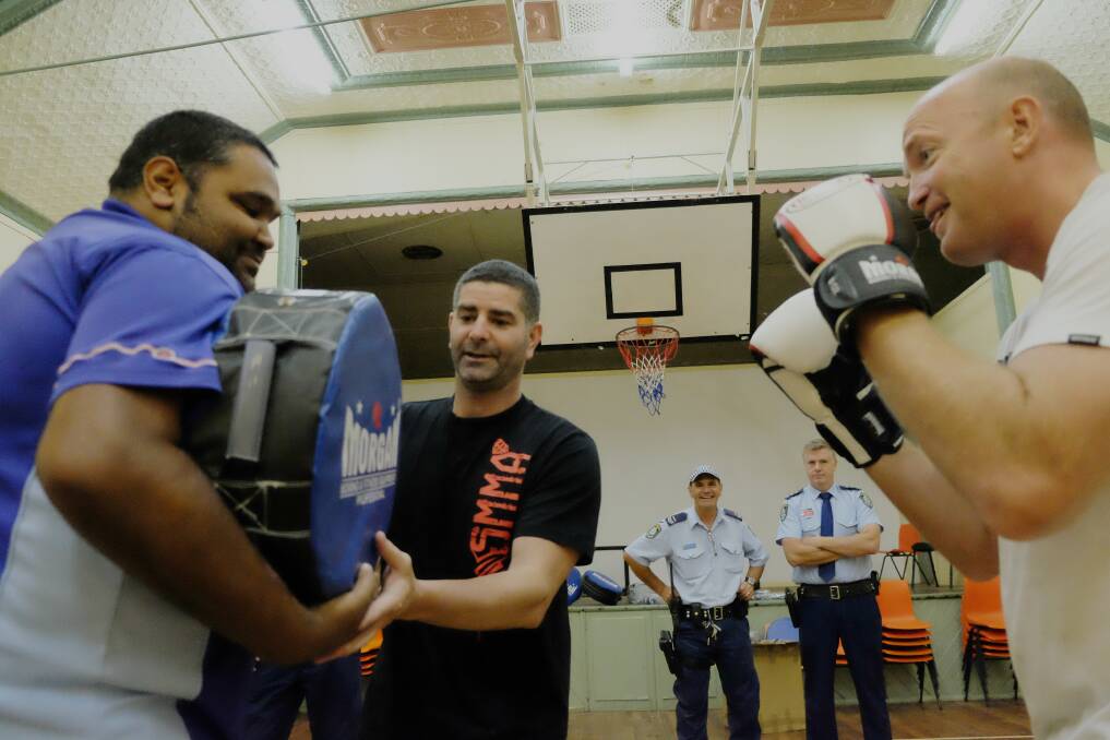 ENCOURAGEMENT: Trainer Darren Finn (centre) coaches on NSW Police Aboriginal Community Liaison Officer Matt Cutmore and Tingha Senior Constable Stephen Caldwell at the Tingha Town Hall on Friday, December 23. Photo: Michèle Jedlicka