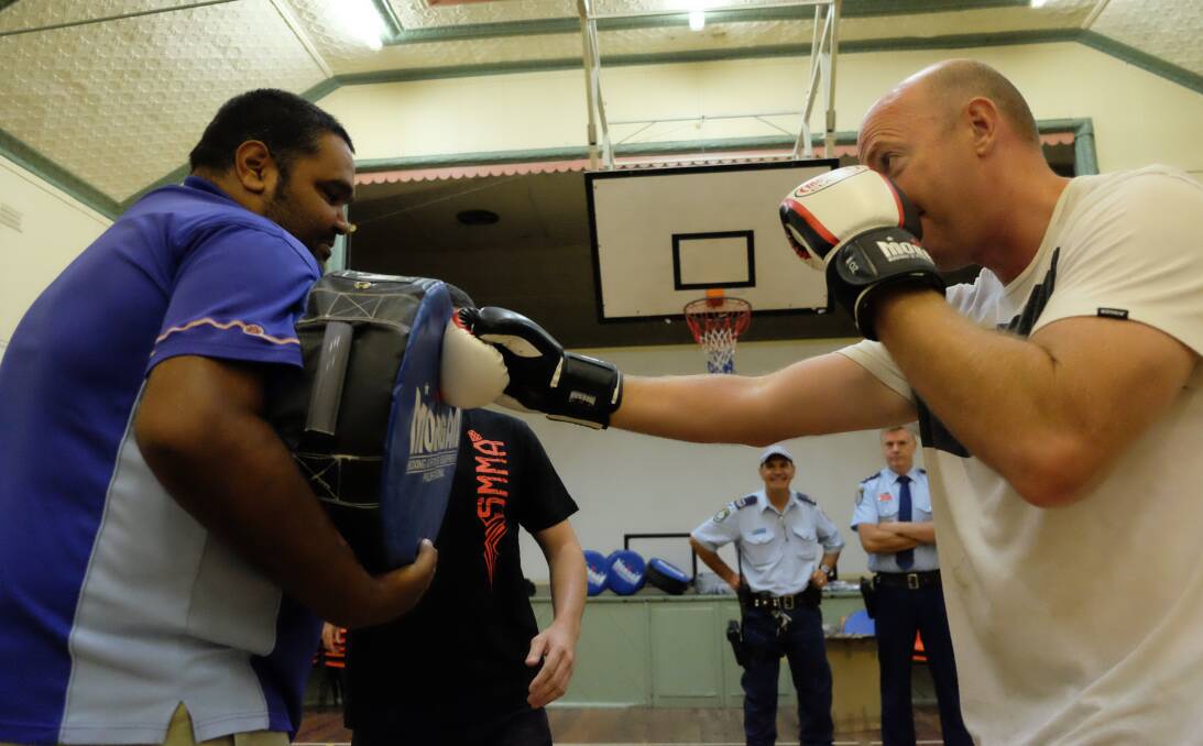 KA-POW: NSW Police Aboriginal Community Liaison Officer Matt Cutmore catches a punch from Tingha Senior Constable Stephen Caldwell at the Tingha Town Hall on Friday, December 23. Photo: Michèle Jedlicka