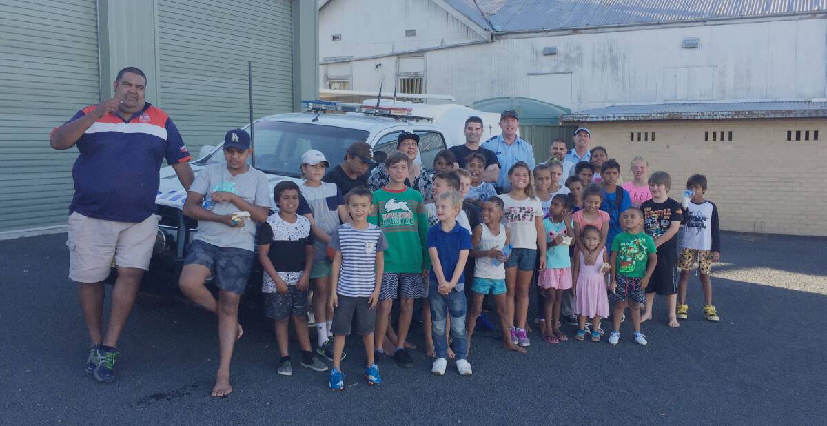 READY: NSW Police Aboriginal Community Liaison Officer Matt Cutmore (left) and Darren Finn with Tingha Sergeant Stephen Caldwell with some of the team of children ready to learn from the December 9 information night . Photo by Will Green