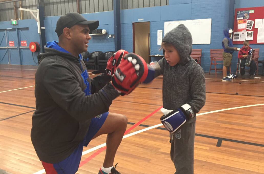 CRIMEFIGHTERS: Clarrie Moran helps out six-year-old Kayden Faulkner at a boxing session. 