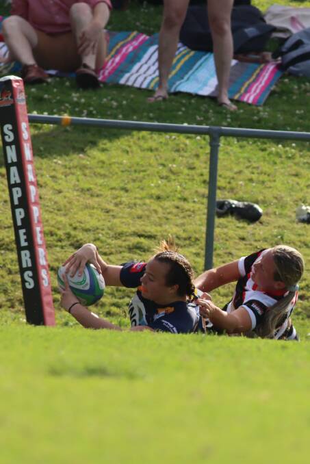 YOUNG TALENT: The Blues' Tas Martin scores a try while the Barbets' Tori Brazier tries to stop her. Photo: Catherine Stephen.