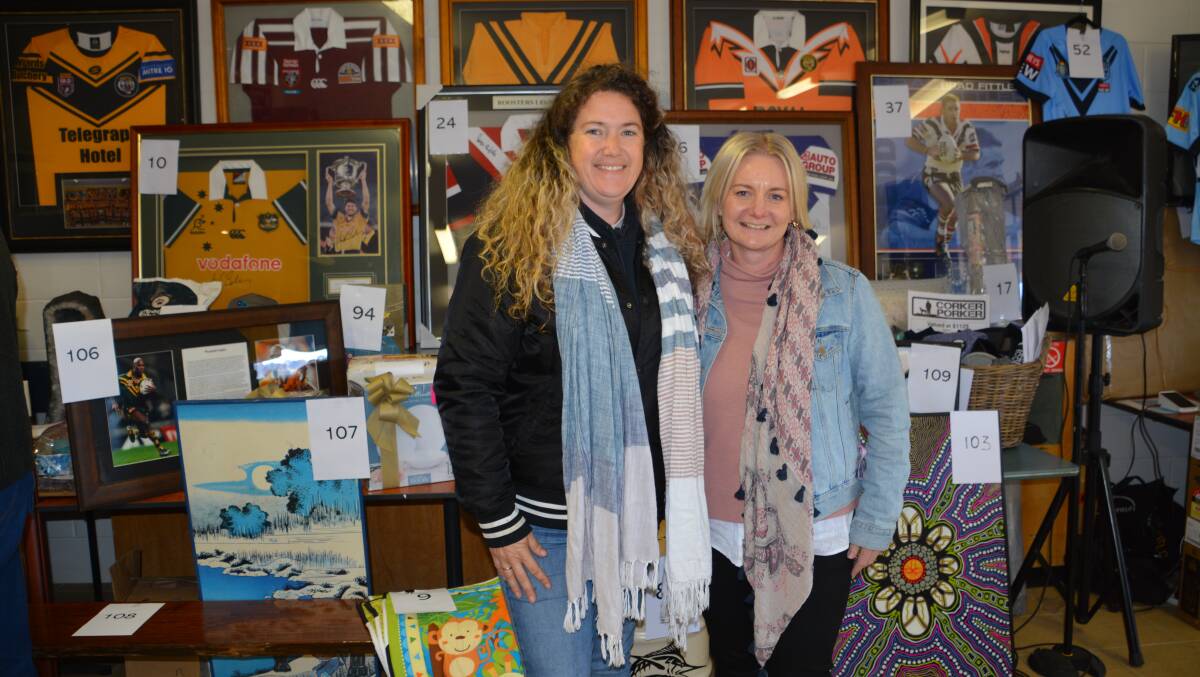 Loz Lavea with one of the organisers, Kristen Lovett, and some of the auction items.