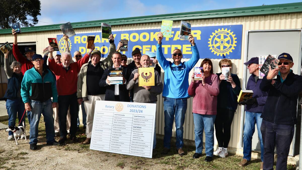 Mayor Sam Coupland - weighed down with books - joins Rotarians at their Book Shed in Dumaresq Street ahead of the annual Rotary Book Fair. Picture supplied. 