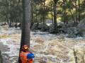 Flood waters: SES rescuers make contact with two people stranded on an island near the blue hole swimming spot. Pictures: Jock Campbell, SES. 