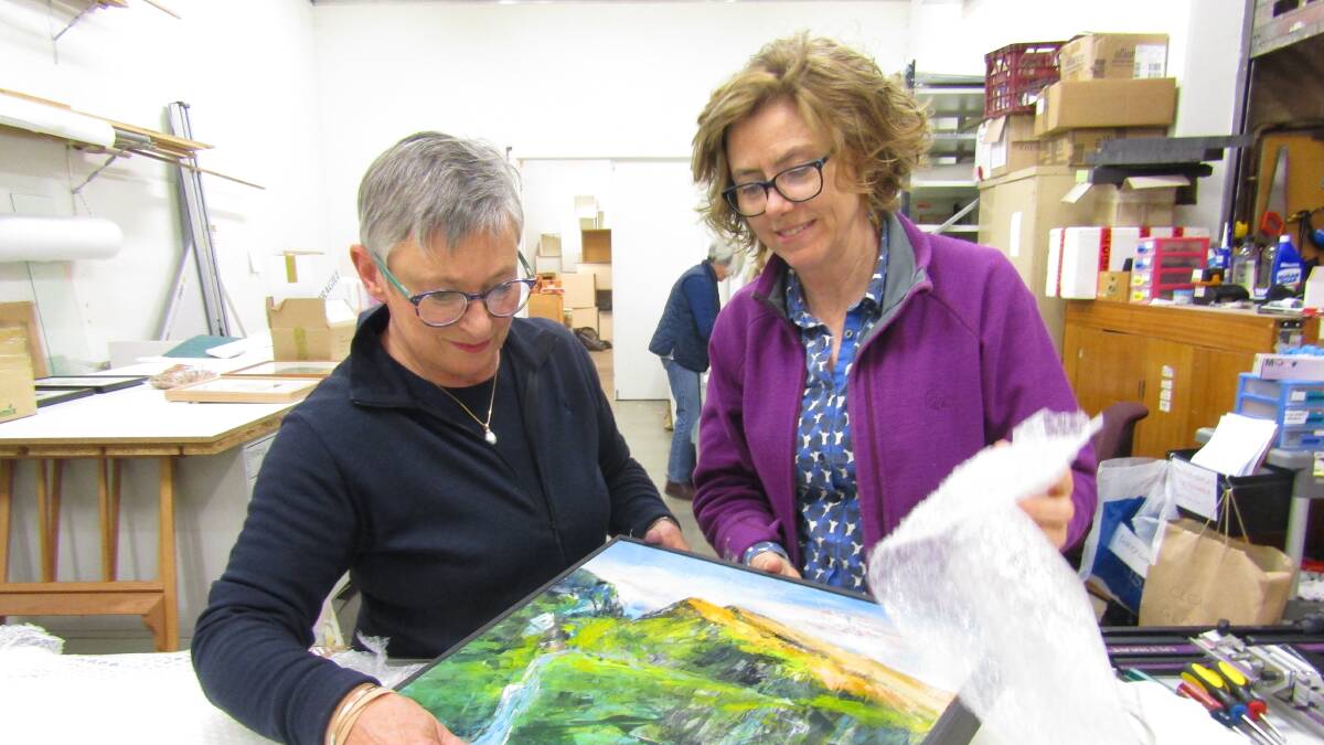 
Packsaddler’s Moira Lloyd and Phillipa Charley Briggs open one of the artworks received for this year’s exhibition