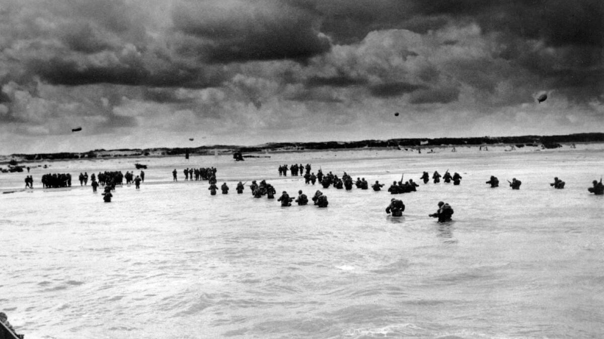US reinforcements wade through the surf as they land at Normandy in the days following the Allies', D-Day invasion of occupied France.