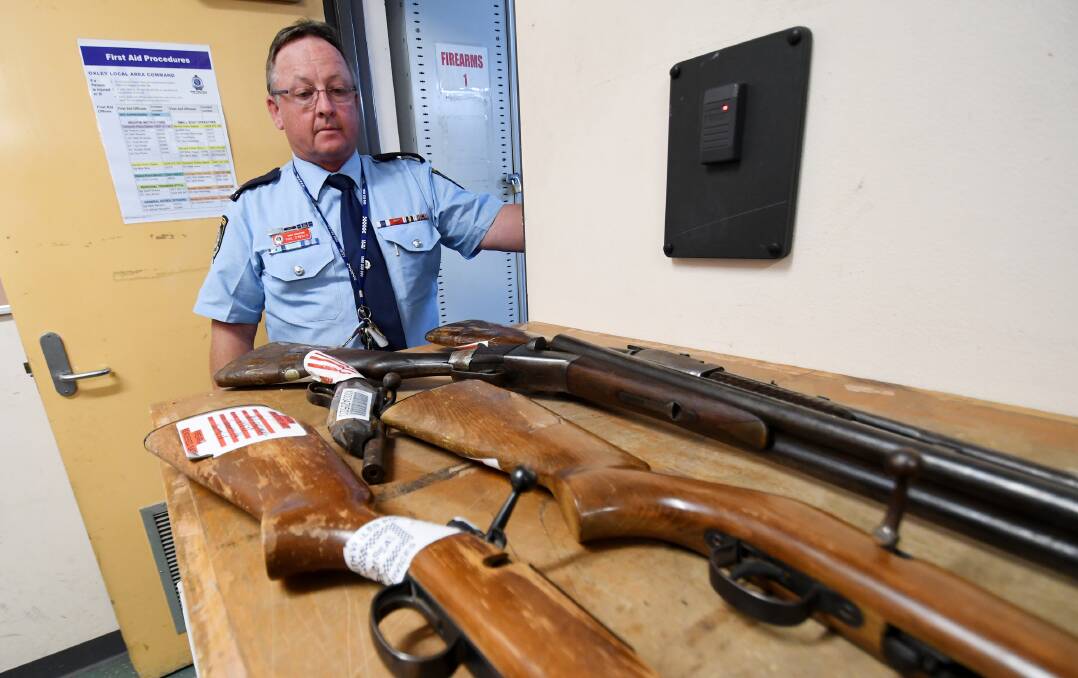 AMNESTY: Oxley Police District Chief Inspector Phil O'Reilly with surrendered firearms. Photo: Gareth Gardner