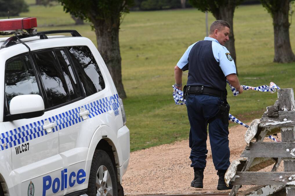 CRIME SCENE: A Walcha police officer out the front off the gate of the 'Pandora' property near Walcha in 2017. Photo: Gareth Gardner