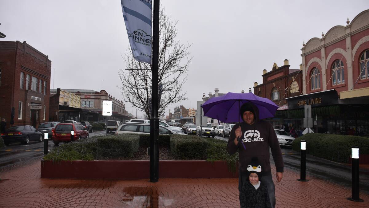 Steve and Isaac Matheson out enjoying the rainy weather in the main street of Glen Innes.