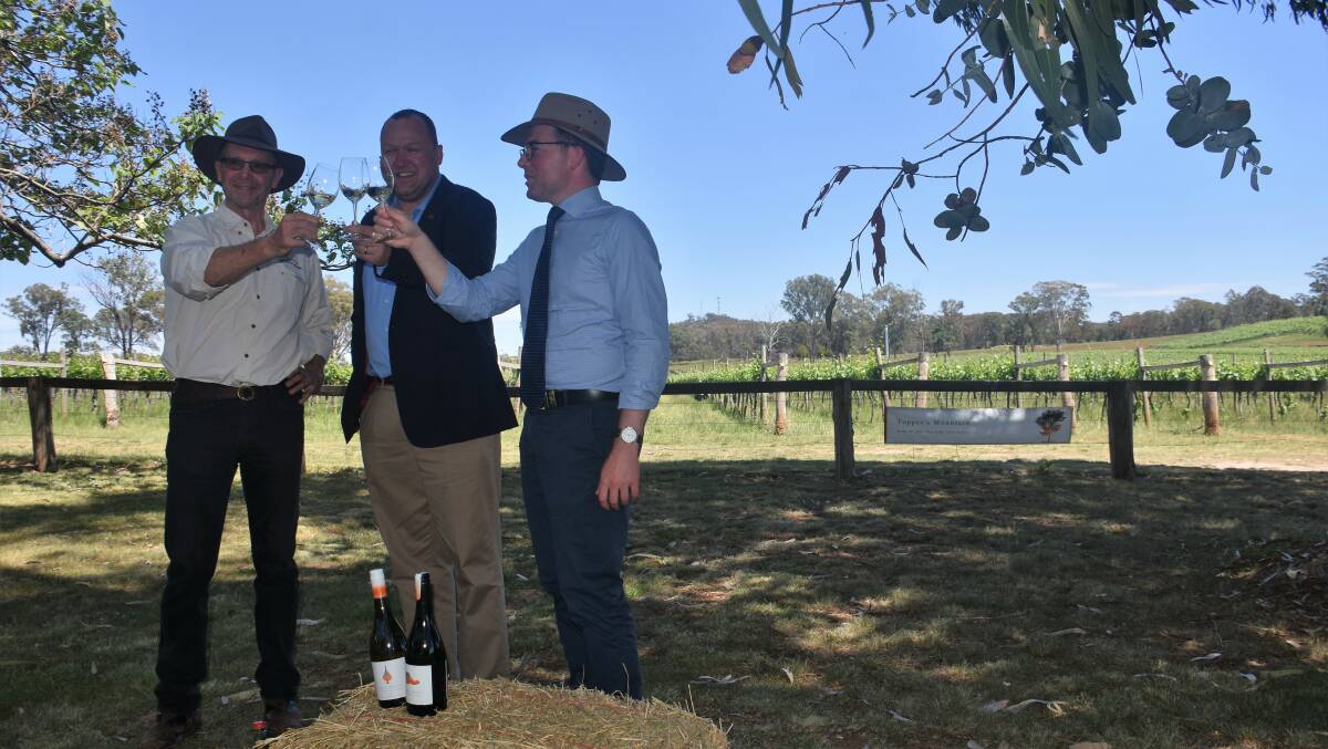 Topper's Mountain Wines owner Mark Kirkby, Angus Barnes from the NSW Wine Industry Association Incorporated and Minister for Tourism and Major Events Adam Marshall toast to the annoucement.