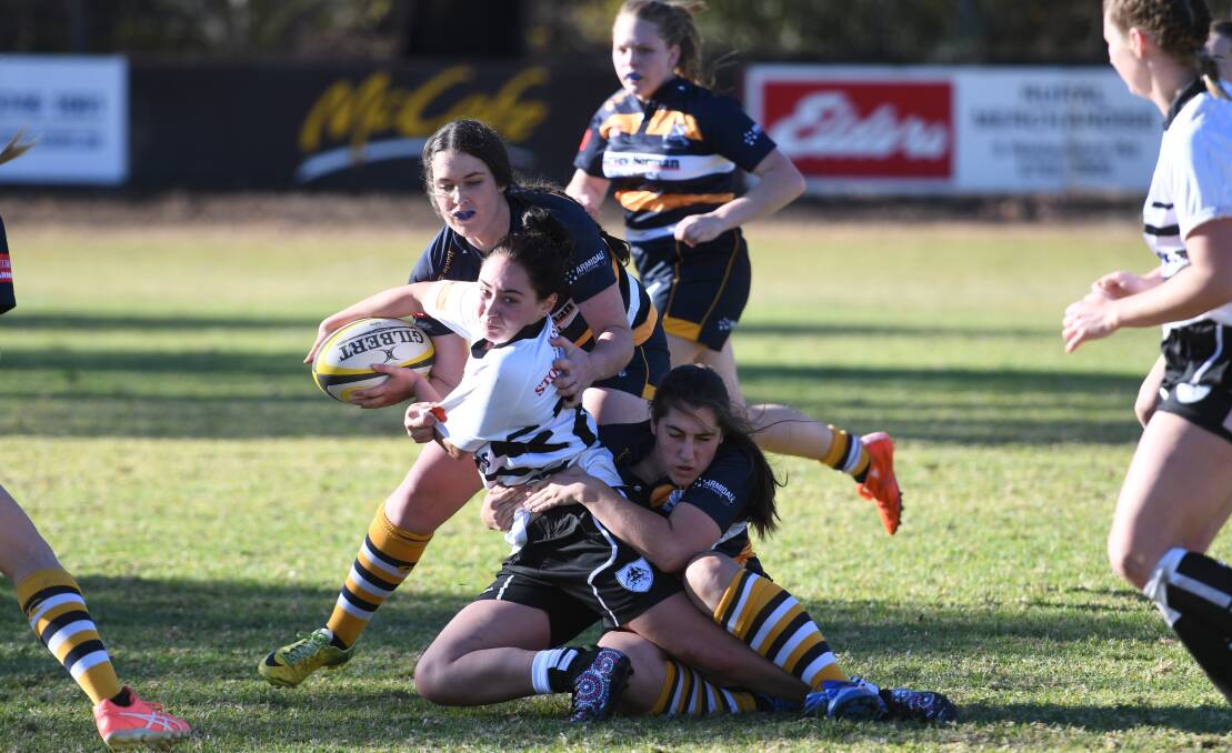 Team effort: Armidale's Natalie Young (bottom) and Abby Brooker combine to bring Tamworth's Montana Rose Ellsley to ground.