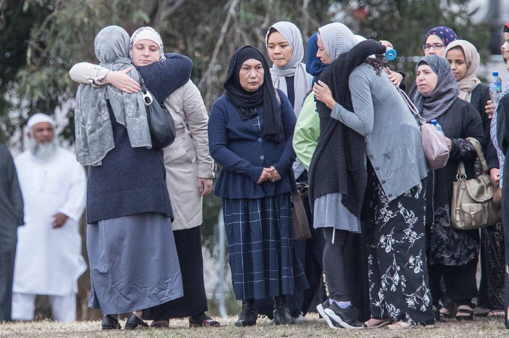 Marginalised: Muslim women hug before the funerals for some of the 50 victims of the mosque shootings at the Memorial Park Cemetery in Christchurch. Picture: Jason South
