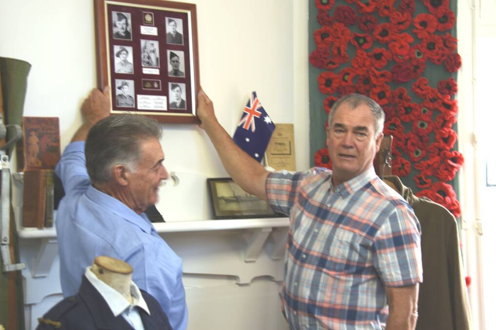 MEN AT WORK: Norman Williams and Cr Simon Murray hanging up the Williams photo montage. Photo - Nicholas Fuller