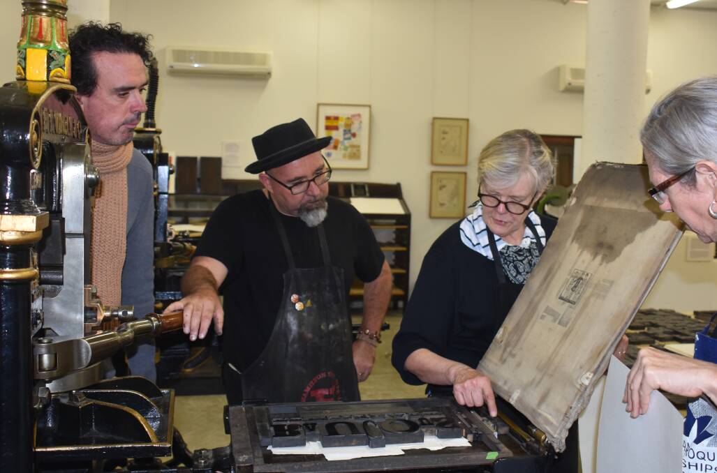 NO PRESS-URE: Clint Harvey and Cynthia Marsh, letterpress experts, show students how to use equipment.