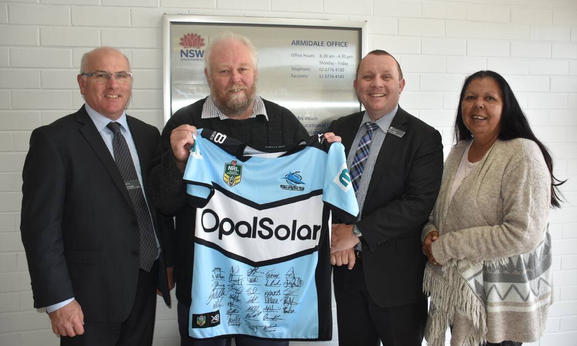 TEAM SPIRIT: Armidale local radio manager Steve McMillan (holding signed jersey) with the Department of Education's Pat Cavanagh, Matt Hobbs, and Carol Green. Photo: Nicholas Fuller