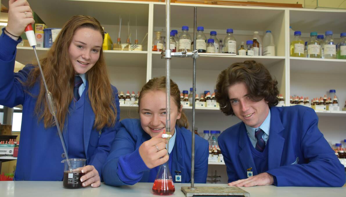 CONCENTRATION: Isabella Kennedy, Meg Lye, and Kieran Wicks have fun in the O'Connor Catholic College science lab, titrating chemicals. Photo: Nicholas Fuller