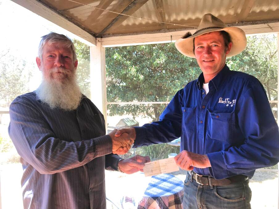 MAKING A DIFFERENCE: Magistrate Roger Prowse presents the cheque to BackTrack's Bernie Shakeshaft. Photo supplied.