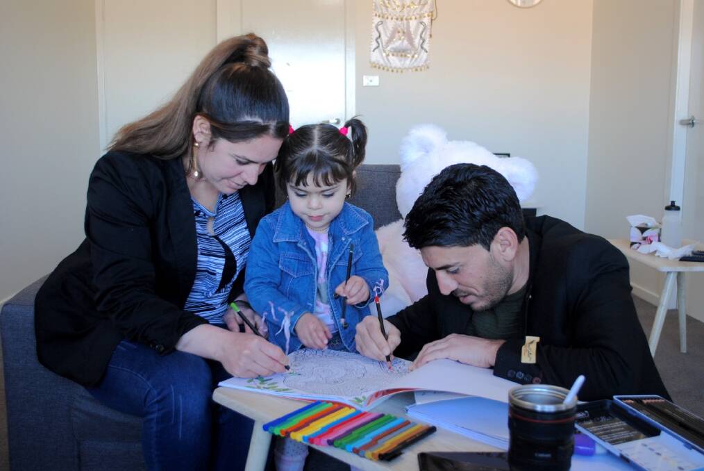 Khalid Adi and his family colouring in. Picture supplied.