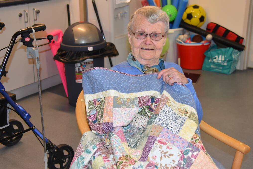 Ken Thompson Lodge resident Lola Baker holds up one of the new lap quilts. Photo: Nicholas Fuller