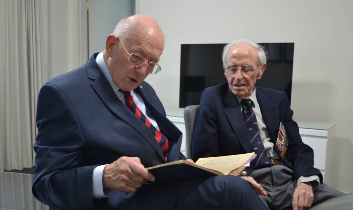 MARKS OF HISTORY: General Sir Peter Cosgrove reads an entry in Sid Handsaker's WW2 flying log book. Picture: Scott Bevan