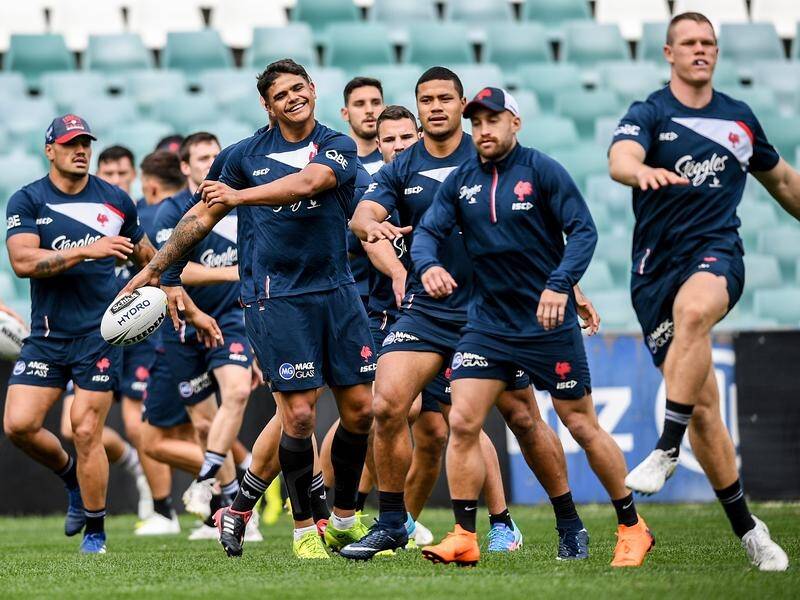 Latrell Mitchell (ball in hand) with his Roosters teammates ahead of the NRL grand final this week.