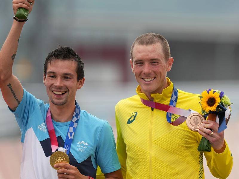 Rohan Dennis (r) celebrates his cycling time trial bronze medal alongside winner Primoz Roglic.