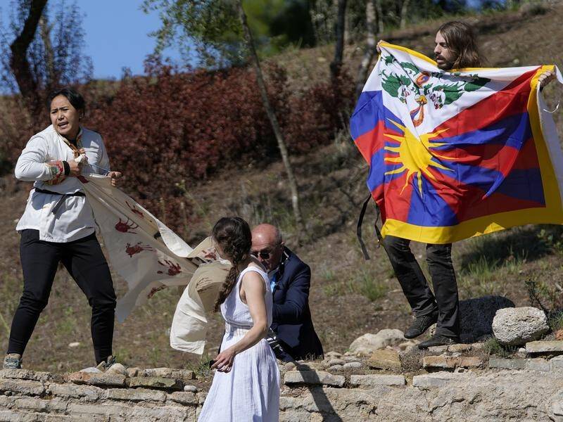 Objectors display a Tibetan flag during lighting of the Olympic flame in protest against host China.