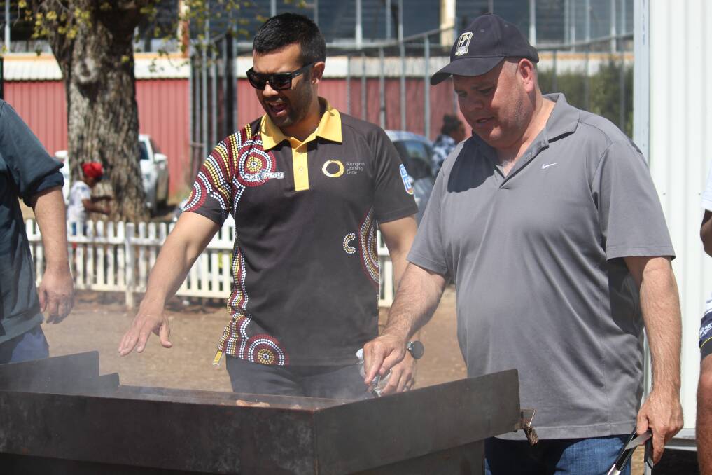 MOST IMPORTANT JOB: Steven Briggs from Armidale TAFE and Cyril Green from Armidale Regional Council man the barbecue.