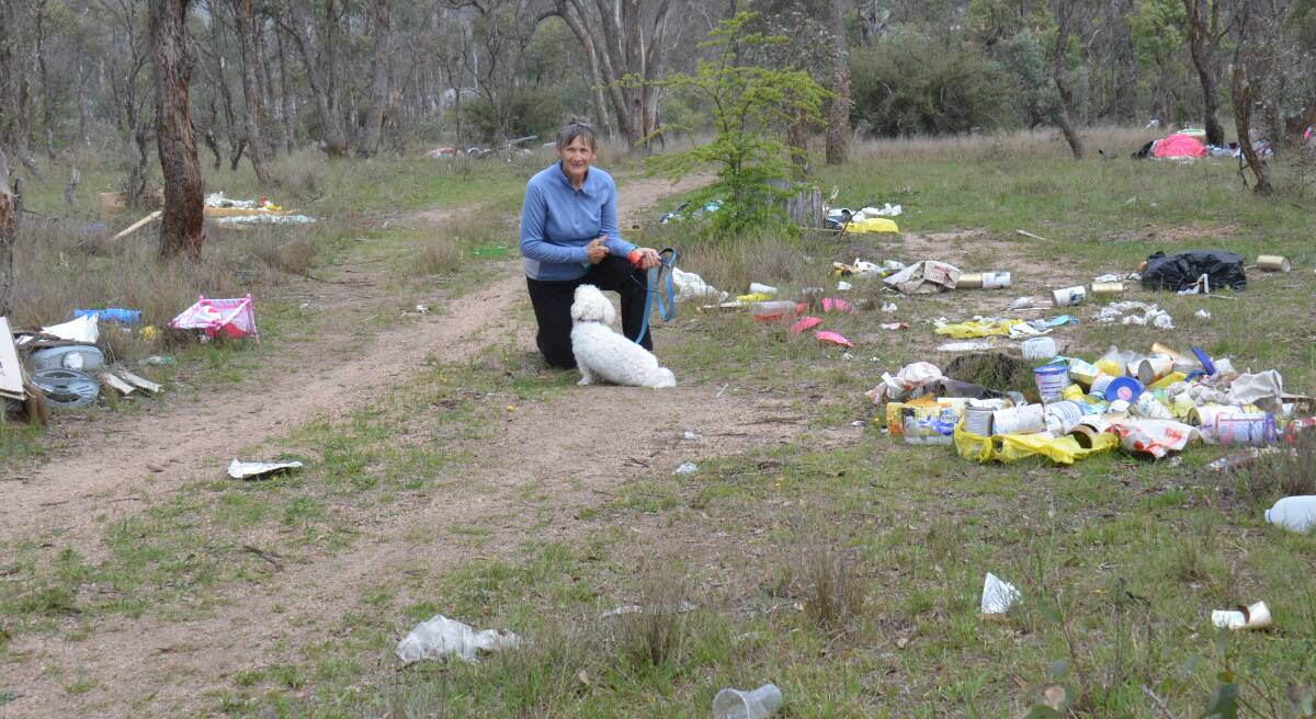 Rita Plummer with her dog "Scruffy" in the middle of a growing refuse tip that nobody wants to clean up.