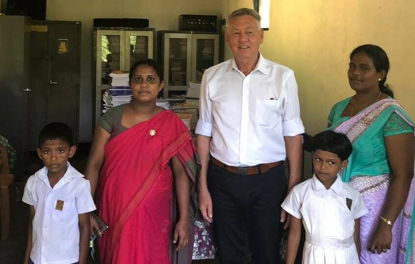 HELP: Former Armidale resident Stephen Gapes in the Ilukpitiya Primary School’s library with students and other members of the school community.