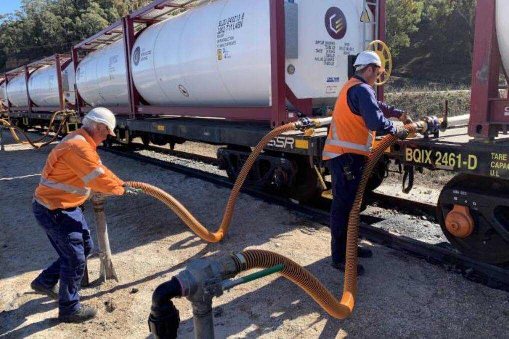 LOADING: Two SSR crew members hooking up hoses to the tank containers. They load up 10 tanks at a time for the full length of the 30 carriage train. (Photograph from Southern Shorthaul Railroad) 