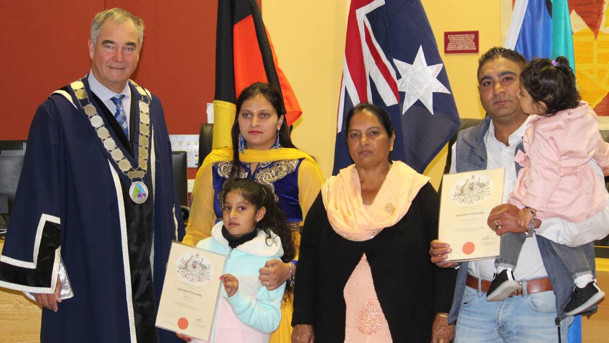 WELCOME: Aadabjit Saini and Varinderjit Singh display their citizenship plaques with their family members.