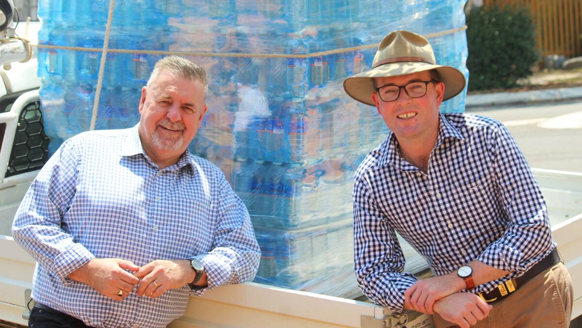 PRECAUTION: Uralla Mayor Michael Pearce and Member for Northern Tablelands in front of part of the load of bottled water delivered to Uralla by the State Government