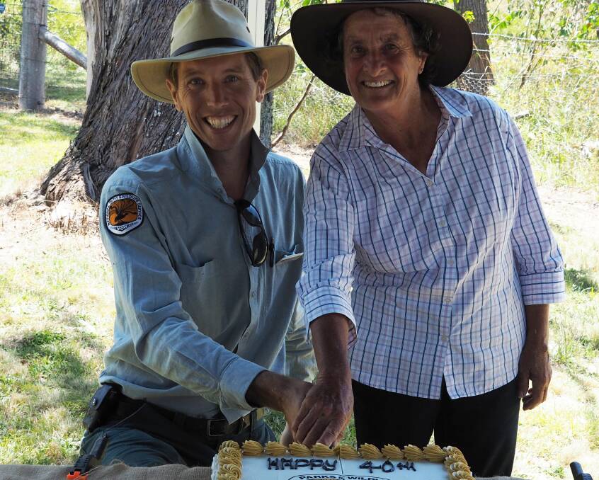 CELEBRATION: Ranger Koen Dijstra and June Walker, a fourth generation neighbouring farmer, cut the cake.