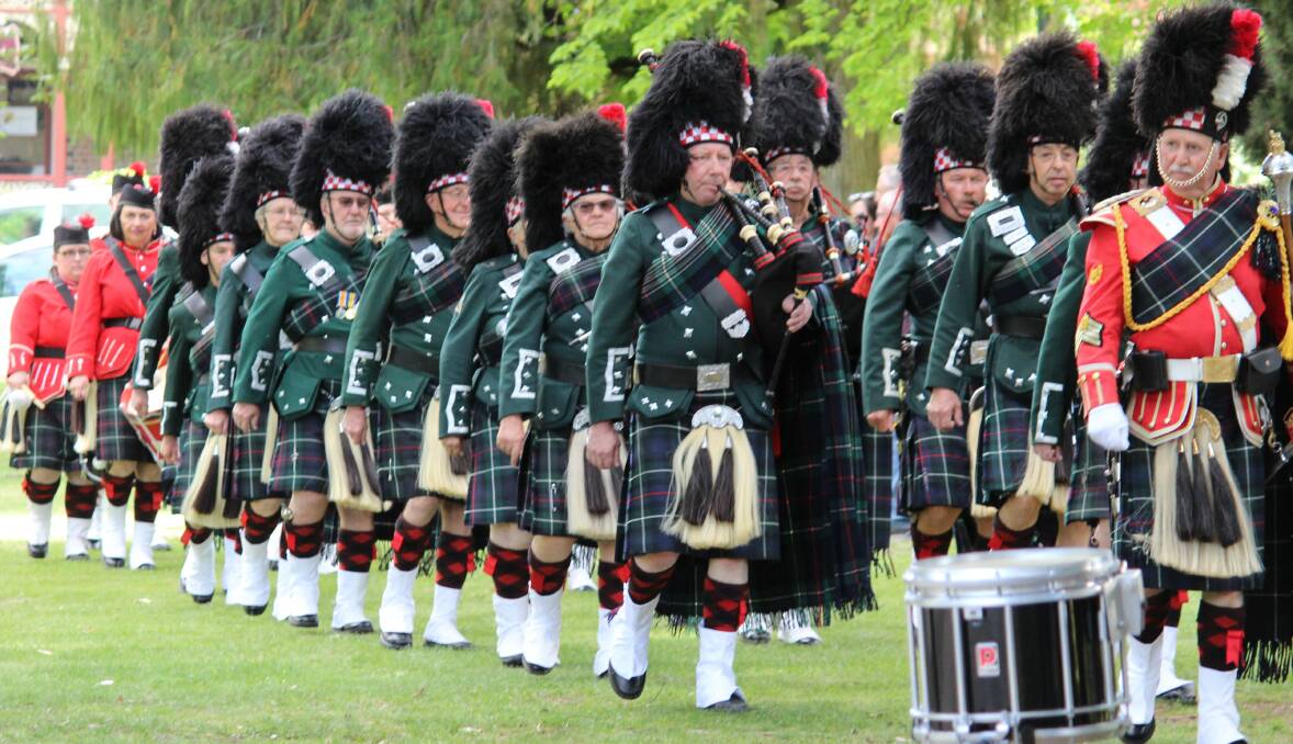 TRIBUTE: Armidale Pipe Band marches into position near the memorial fountain just before 5pm.