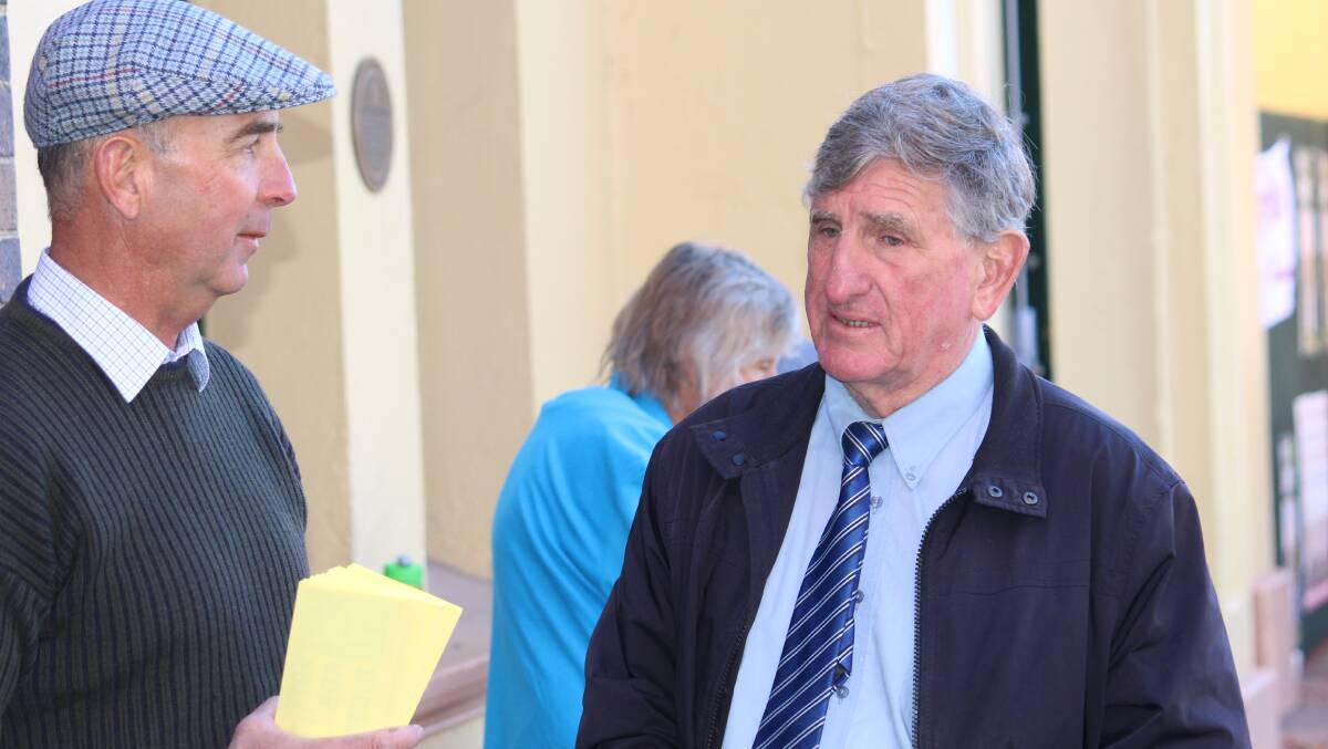 TOUCHING BASE: Andrew Wood and Independent candidate Rod Taber chat as they hand out how to vote cards outside the Armidale Town Hall this morning.