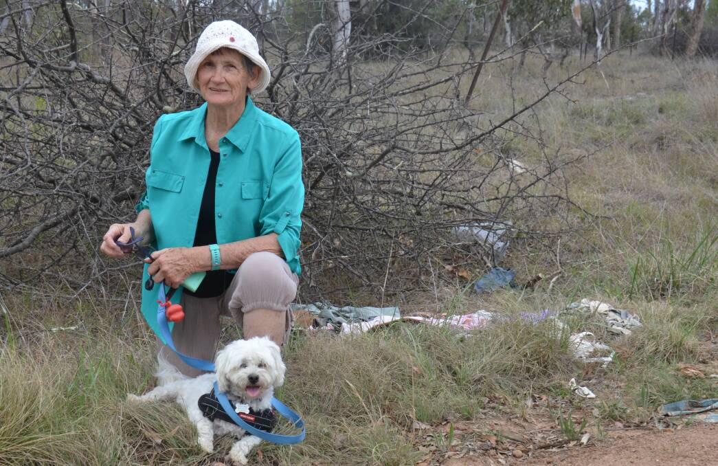 Rita Plummer with her dog "Scruffy" in front of a trailer load of rubbish and garden waste.