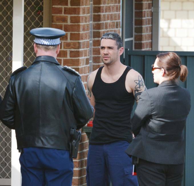 Damien Linnane being placed under arrest outside his home following a police raid.
