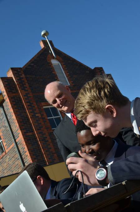 Mitchel Hanlon looks over as students from The Armidale School use their new devices with the aid of the antenna seen in the background.