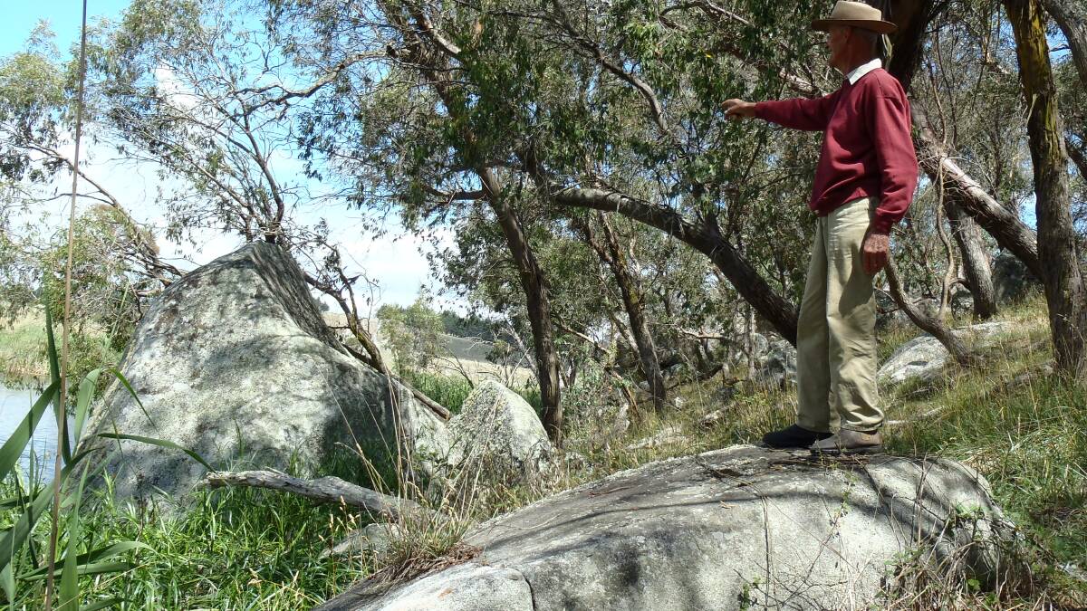 ON POINT: Historian Arnold Goode points to the distinctly shaped granite ‘pillar’ several metres high that enabled him and the geologists to locate the site of the shooting.